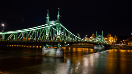 Fototapeta na wymiar Freedom Bridge in Budapest, Hungary.Night. Reflections of lights on the water.
