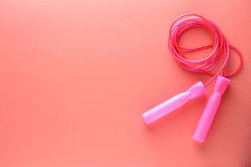 Pink jumping rope or skipping rope isolated on pink background. Sports, fitness, cardio, healthy workout concept.