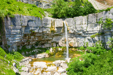 The Kinchkha waterfall in the canyon of the river Okatse. Rest in Georgia. High waterfall in the Imereti region. Rocky ledges of the mountain with green trees.