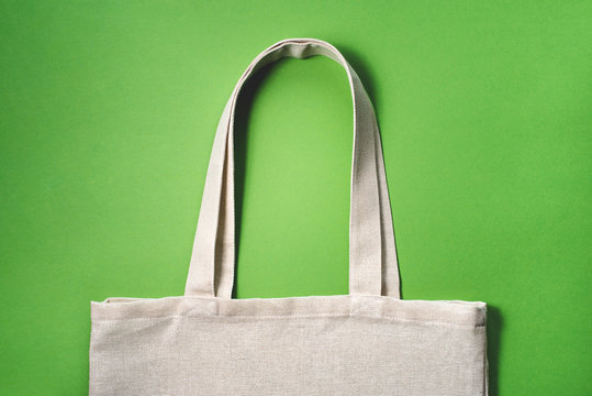 Fabric eco-bag on green background. Flat lay, close up.