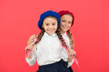 True friends always stand beside you. Friendship means support. Girls best friends on red background. Cute playful sisters schoolgirls having fun. Kids long braids hairstyle classmates friends