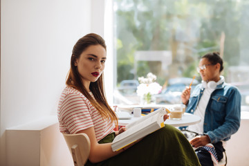 Attentive longhaired girl looking straight at camera