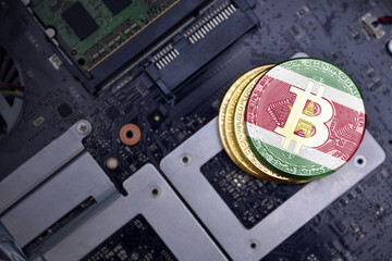 golden bitcoins with flag of suriname on a computer electronic circuit board. bitcoin mining...