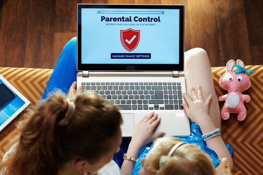 mother and daughter setting up parental control on laptop