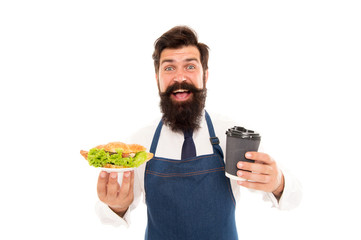 Cafe food concept. Enjoy your meal. Guy serving croissant stuffed lettuce and fresh vegetables. Healthy food. Combo meal. Man bearded waiter giving plate with food and coffee cup. Delicious croissant