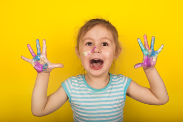 Little girl on a yellow background shows hands drawn