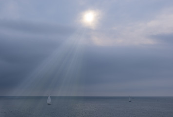 sailboat in the sea with light of the sun at sunset