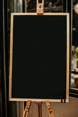 Leere Tafel mit Holzrahmen auf Staffelei mit Textfreiraum 