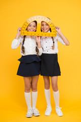 mired in geometry. Maths and geometry. Kids in uniform at yellow wall. friendship and sisterhood....