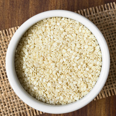 White sesame seeds in small bowl, photographed overhead with natural light (Selective Focus, Focus on the seeds on the top)