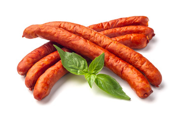 Dry Sausages with basil leaves, close-up, isolated on white background.