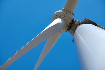 Electricity wind generator on bright cloudy sky background - wind energy and technology concept