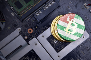 golden bitcoins with flag of abkhazia on a computer electronic circuit board. bitcoin mining...