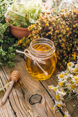 Flower honey in a glass jar, harvesting wild medicinal herbs