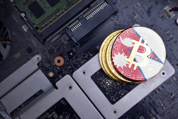 golden bitcoins with flag of nepal on a computer electronic circuit board. bitcoin mining concept.