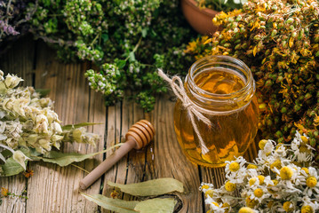 Flower honey in a glass jar, harvesting wild medicinal herbs © yakovlevadaria
