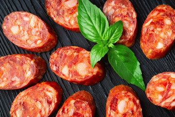 A french saucisson - dry summer sausage on the black background.