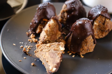 Anthill chocolate cake dessert on a gray plate. Black table in the kitchen.
