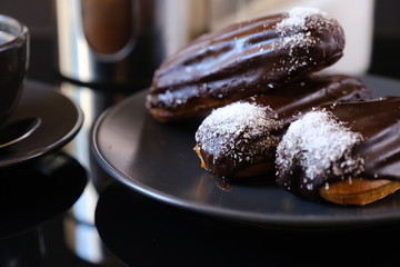 chocolate eclairs on a plate and cup of coffee. traditional fcench Chocolate Eclairs