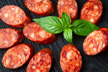 A french saucisson - dry summer sausage on the black background.