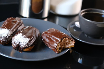 chocolate eclairs on a plate and cup of coffee. traditional fcench Chocolate Eclairs