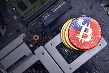 golden bitcoins with flag of taiwan on a computer electronic circuit board. bitcoin mining concept.
