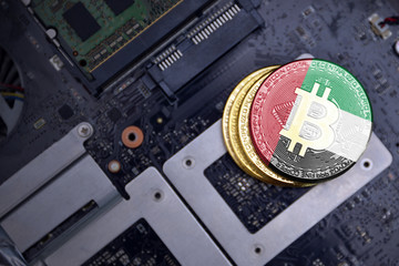 golden bitcoins with flag of united arab emirates on a computer electronic circuit board. bitcoin...