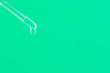 Serum for cosmetic procedures. Serum on a green background. Cosmetic pipette with a drop....