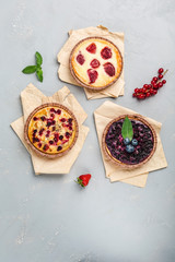 Apple, blueberry and strawberry pies on a light background top view with copyspace