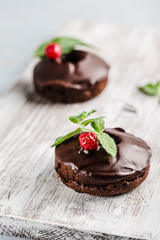 chocolate donuts with raspberries on a light background