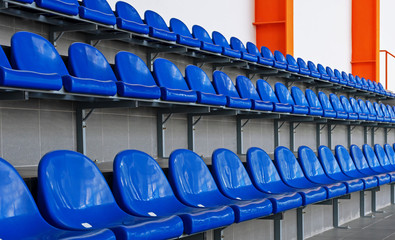 Blue plastic seats in the stadium. Tribune fans. Seats for spectators in the stadium.