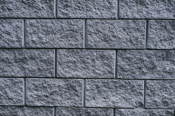Gray city brick wall. Dark grey background. Copy space for text.