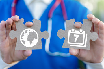 International world health day concept. Doctor or pharmacist holds two puzzle pieces with calendar...