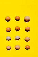 An eggs pattern. A different sizes eggs on a yellow background. Eggs background close-up. Eggs texture wallpaper. Diversity concept. Top view. Concept for designers copy space. An eggs and only eggs.
