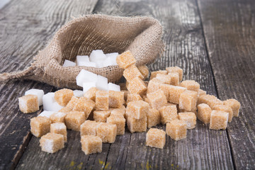 Various types of  refined sugar, brown sugar and white, wooden background