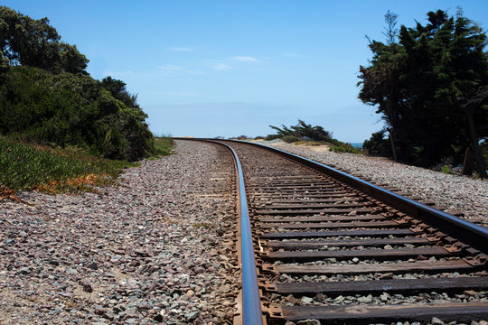 Railroad Ties And Track Surrounded By Shrubbery At A Curve In Del Mar, California