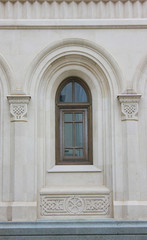 Arched window frame on old house facade 