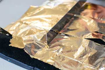 Gilding theme with a leaf of beaten gold and blade