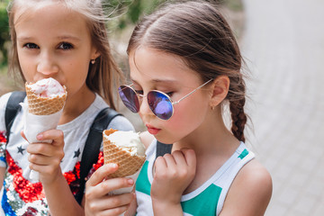 Portrait of 8-9 years old kid girls eating tasty ice cream outdoor