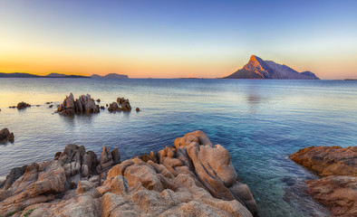 Fantastic azure water with rocks near beach Porto Taverna at sunset