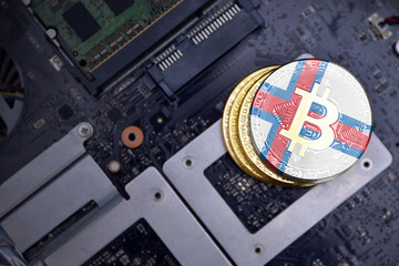 golden bitcoins with flag of faroe islands on a computer electronic circuit board. bitcoin mining...