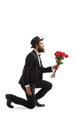 Bearded man kneeling and holding red roses