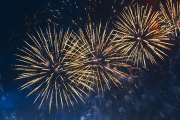 Inexpensive yellow fireworks over blue sky with colour sparks. Selective focus. Bright and shiny. Celebration concept.