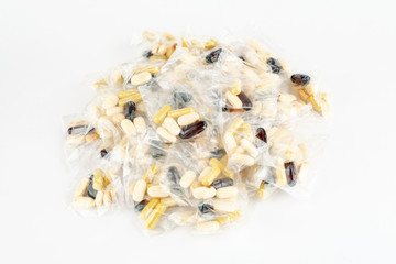 Pills dosage in plastic bag on white background, top view