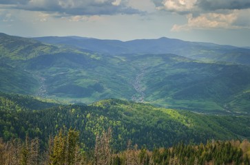 Amazing spring mountain landscape. Shadows and lights on the trees in the hills.