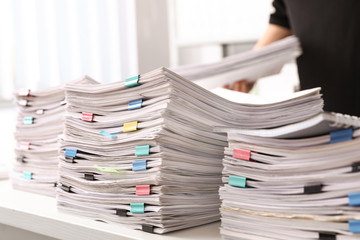 Stacks of documents with paper clips on office desk