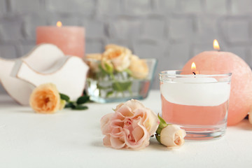 Burning candles and fresh flowers on white table, space for text