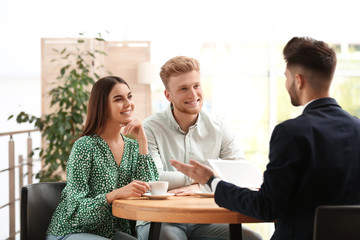 Insurance agent working with young couple in office