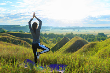 Girl in the nature doing yoga exercise for fitness.