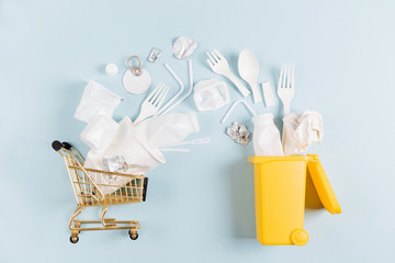 White single use plastic falling out of shopping cart in garbage bin.  Environmental, pollution...